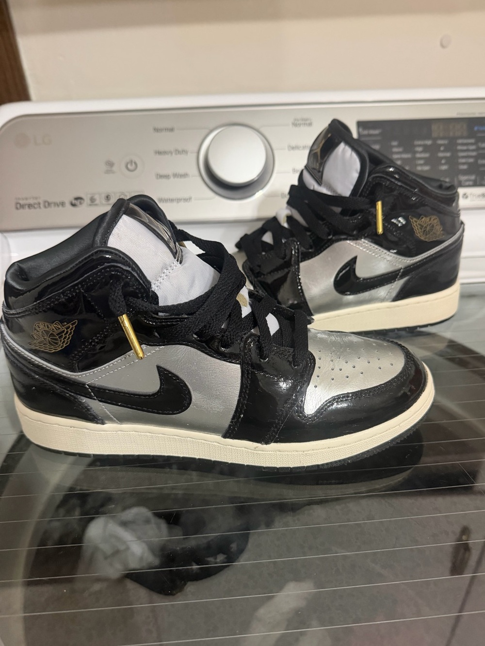 Air Jordan 1 Mid Black and Silver Patent Leather Sneakers.